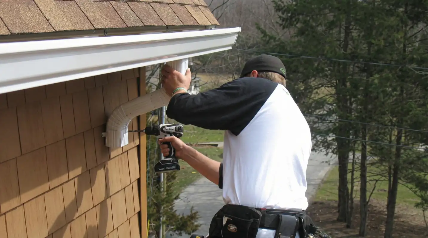 Professional contractor installing tan vinyl siding panels on a residential home exterior in Columbus, OH